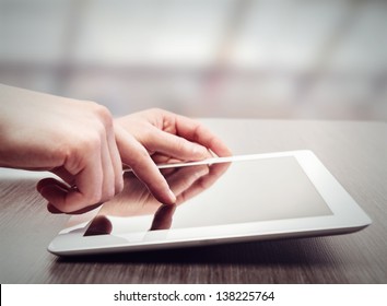 White Tablet With A  Blank Screen In The Hands On Wooden Table