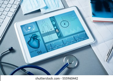 White tablet pc and doctor tools on gray surface