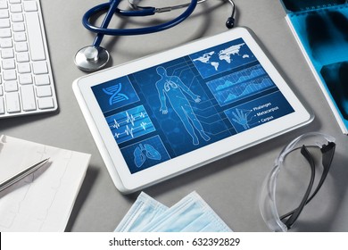 White tablet pc and doctor tools on gray surface