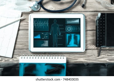 White tablet pc and doctor tools on wooden table - Shutterstock ID 748403035