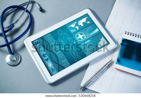 White tablet\
pc and doctor tools on gray\
surface