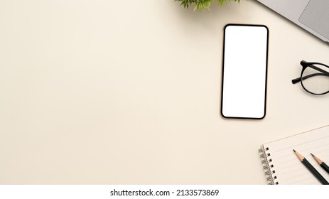 White Tabletop Workspace With Smartphone White Screen Mockup, Accessories And Copy Space. Top View