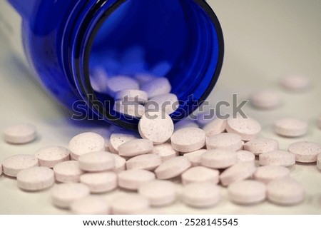 White tablets and blue container for nutritional supplements. In reality these are chromium picolinate tablets