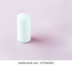 A White Tall Candle On The Light Pink Background With Copy Space