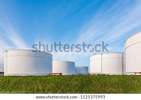white tanks for petrol and oil in tank farm with blue sky