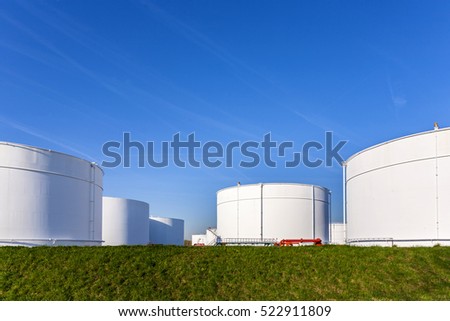 white tanks in tank farm with blue clear sky
