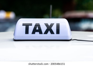 White Taxi Sign on Top of Car