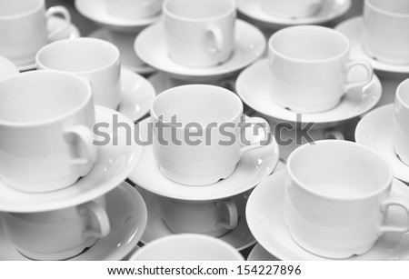 A lot of white tea cups. Focus on the center.