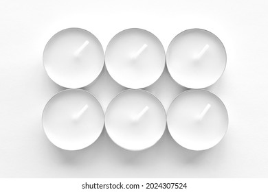 White tea light candles on white background. 
