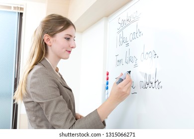 White teacher writing on the white board - Shutterstock ID 1315066271