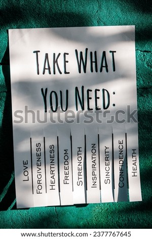 White tear-off stub note with text 'Take what you need' on emerald wall. 