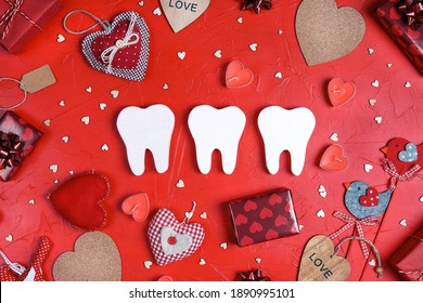 White teeth surrounded by gifts and hearts on red background. Dental Valentine card. Valentine's day concept. 