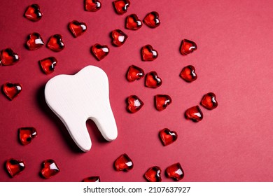 White teeth surrounded by red hearts on a red background. Dental Valentine card. Valentine's day concept.  