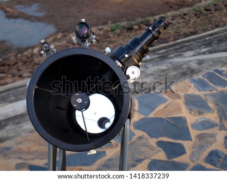 White telescope for watching close-up stars Overlooking the inner reflector plate installed on the stone courtyard of the public reservoir On a cement background and ground 