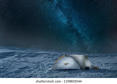 White tent is illuminated from the inside under a clear sky displaying the Milky way on top of Uludag Mountain, Turkey - Shutterstock ID 1198833544