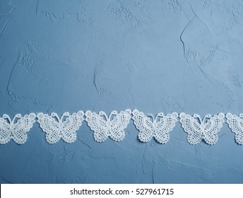 White textile butterflies on concrete blue background. Flat lay, view from above, copyspace for text