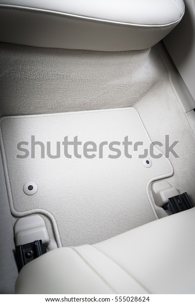 White textile car mat with floor holders in\
white car interior