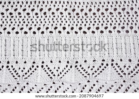 White textured background of openwork knitted fabric.