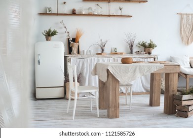 White Textured Kitchen In The Style Of Shabby. A Large Table In An Ecological Style And Loft Style. Rustic Shelves, Napkins, Old Refrigerator, Diy