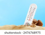 White Thermometer Measuring Temperature on a Sandy Beach