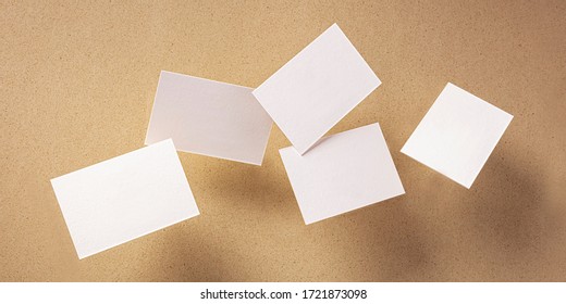 White thick business cards, flying on a brown paper background, a panoramic mock-up for design presentation