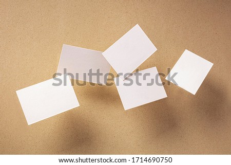 White thick business cards, flying on a brown paper background, a mock-up for a creative design presentation