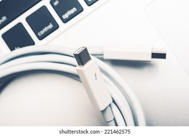 White Thunderbolt Cable And The Laptop Keyboard