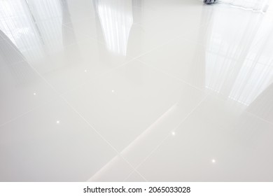 White tile floor with grid line of square texture pattern in perspective. Clean shiny of ceramic surface. Modern interior home design for bathroom, kitchen and laundry room. Empty space for background