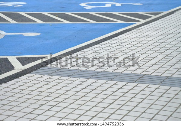 White tile ground floor and parking with paint the\
wheelchair in outdoor\
space