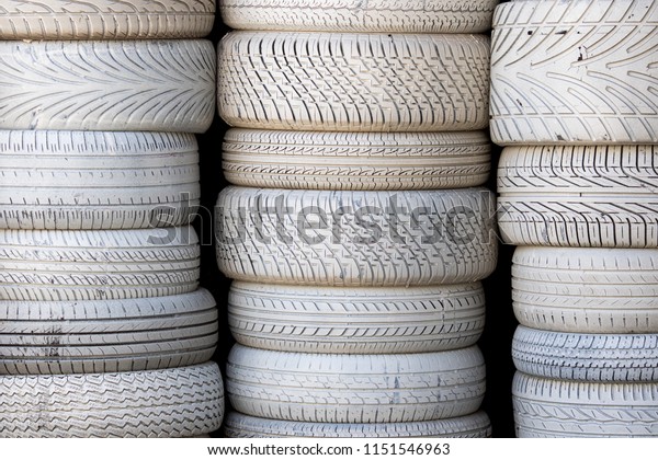 White tires. Stack of\
car tyres painted white. Automobile background image. Petrol-head\
or car vehicle enthusiast backdrop. Variety of tire types stacked\
to make a wall.