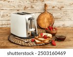 White toaster with bread slices, strawberries and jam on wooden background