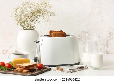 White toaster with healthy food and drinks on table in light kitchen
