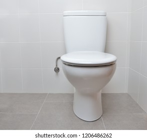 White Toilet Bowl In A Bathroom With The Lid Closed