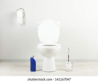 White Toilet Bowl And  Cleaner Bottle In A Bathroom