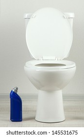 White Toilet Bowl And  Cleaner Bottle In A Bathroom