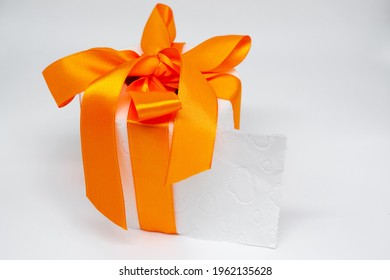 White Toilet Paper Roll Tied With Bright Orange Satin Ribbon As A Gift
