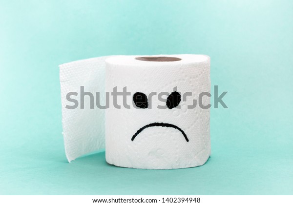 White toilet paper with\
sad face. Creative concept constipation, indigestion, digestion\
problem.