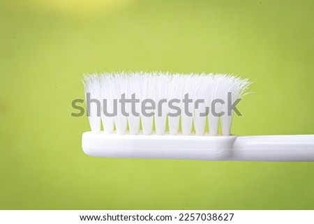 White toothbrush on green background Taken at close range, let the brush bristles be used until they are not straight.