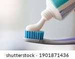 White toothpaste is applied to toothbrush. Oral Care Concept