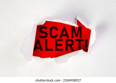 White Torn Paper With A Text Of Scam Alert On Red Cardboard With Copy Space.