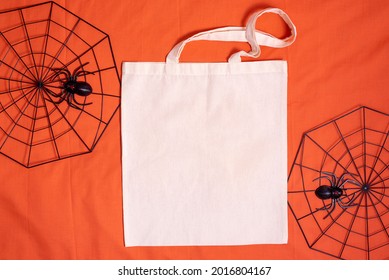 White tote bag canvas fabric. Cloth shopping sack mockup with copy space with spiderweb on orange background.