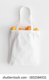 White Tote Bag Mockup With Fruit On A White Table.