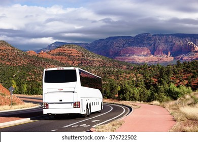 White tourists bus cornering on street road in Sedona, USA. Bus with tourists on the background of the city of Sedona. Bus with tourists on a background of red rocks in the valley Sedona city