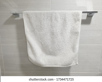 White towel for wiping the hand hanging from the toilet.