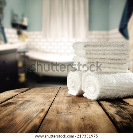 white towels in bathroom and free space on retro table for you in vintage bathroom 