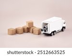 White toy truck with boxes on a light background, space for text. Logistics and wholesale trade concept.