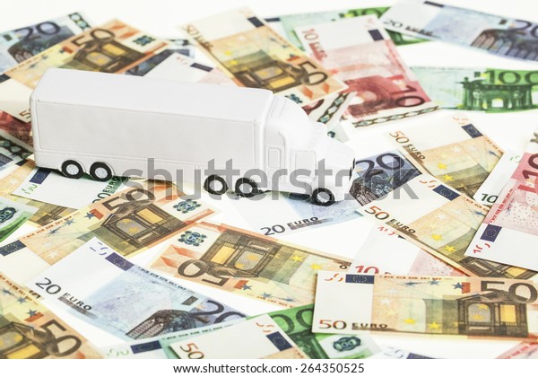 white toy truck on euro banknotes.\
concept for logistics, transportation and and\
finance
