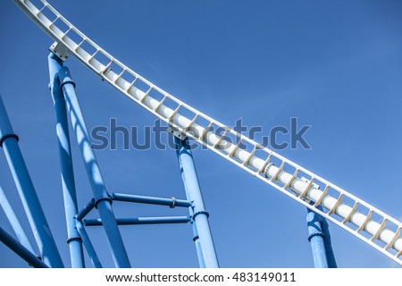 white tracks of steel roller coaster with blue steel supporting tubular against blue sky