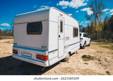 Caravana remolque blanco coche está aparcado en el lado de la carretera. La escena es tranquila y silenciosa, lista para vacacionar