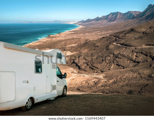 White travel caravan car stay on the\
beautifull ocean coastline with natural view in sunny day. Freedom,\
Family, Travell, Journej, Travelers\
concept.